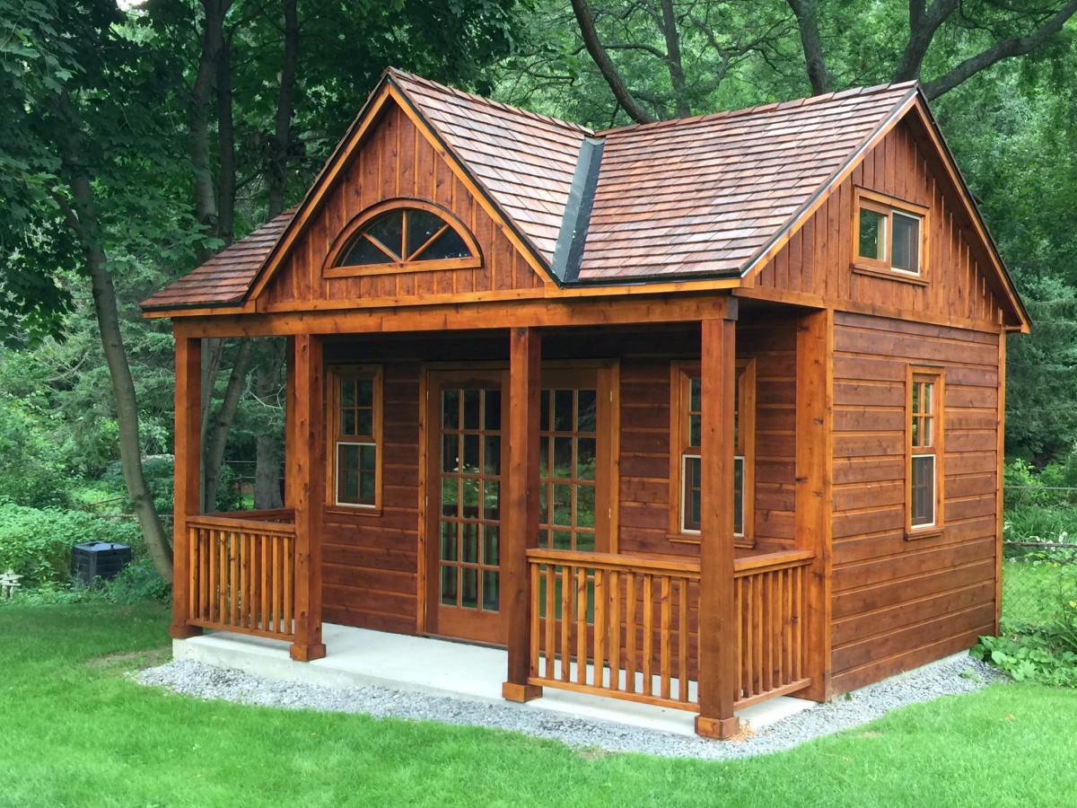 Canmore cabin design 14x16  with large clear sliding windows and french doors in a yard seen from the right. ID number