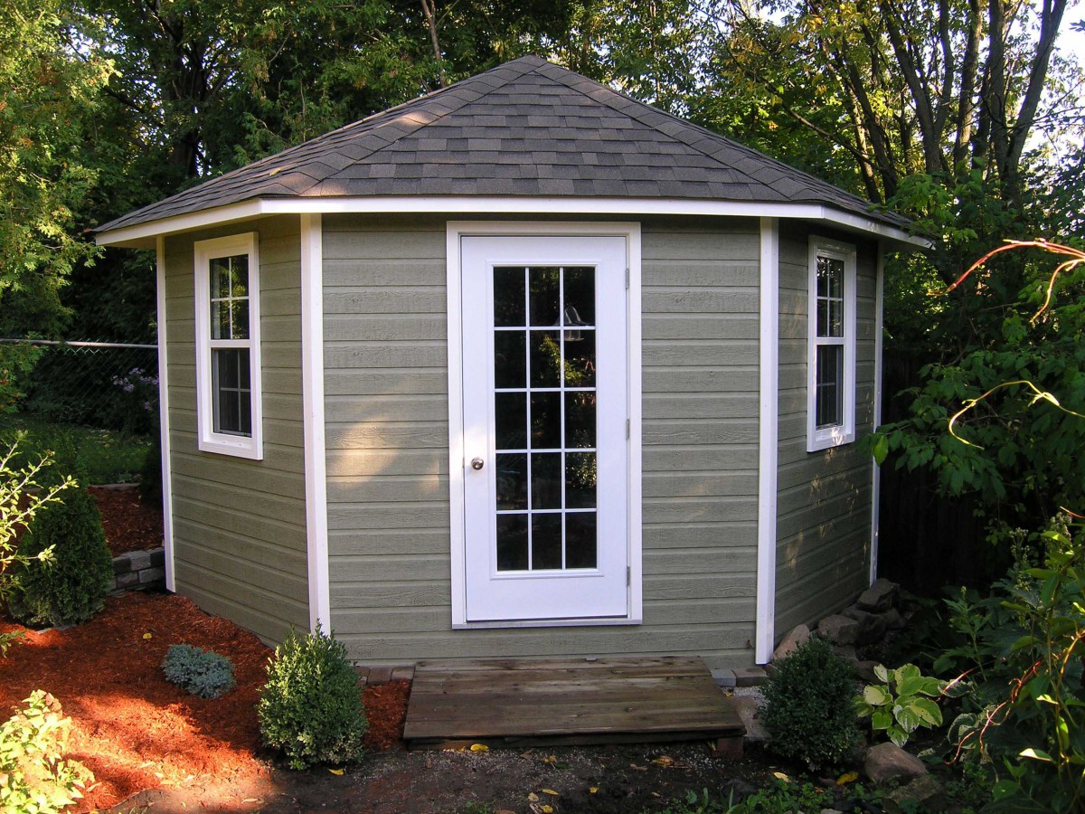 Catalina shed design 11 ft with a white door and windows in a backyard seen from the front. ID number 1785-3.