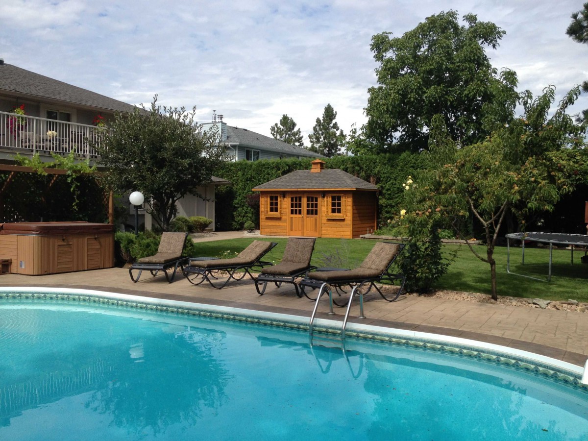 Sonoma pool house design 9 x 16 with double arched deluxe doors in a backyard seen from the far. ID number 3107-2.