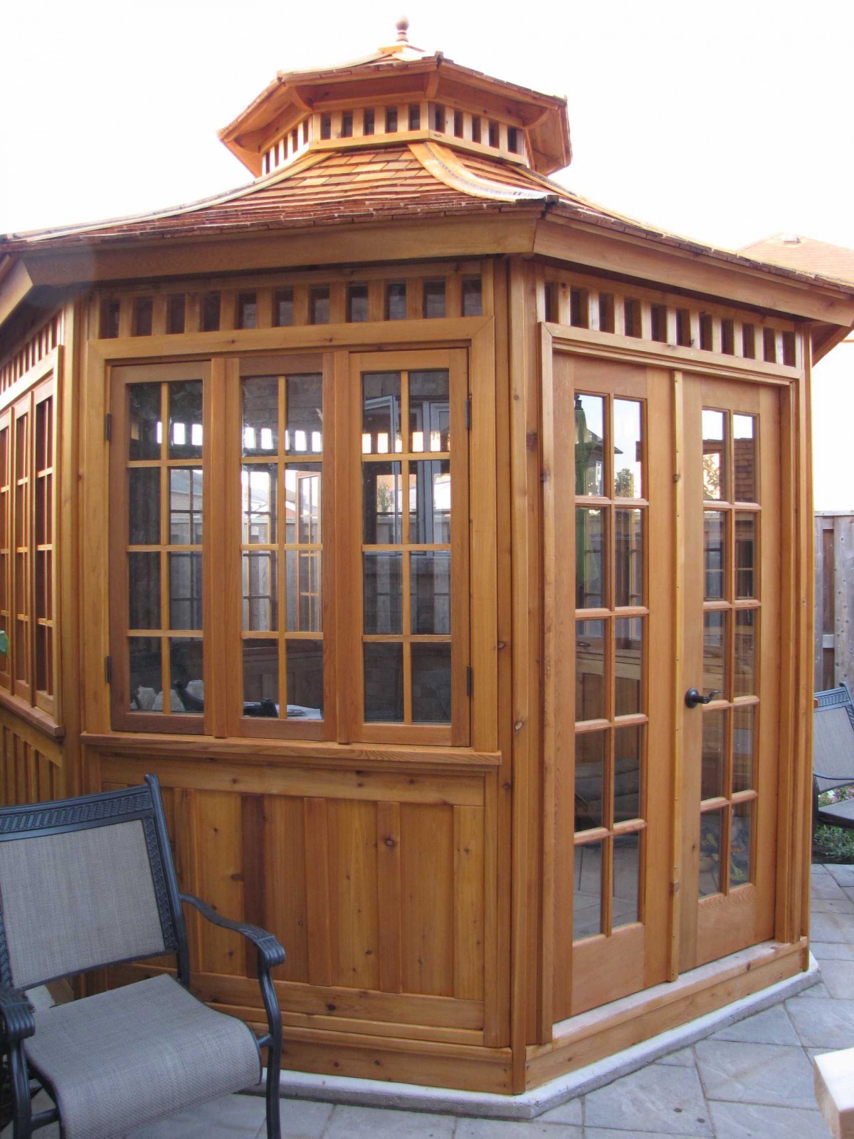 San cristobal Gazebo plan 11' in backyard with stained finish seen from left.ID number 3412-2.