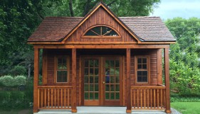 Canmore cabin design 14x16  with large clear sliding windows and french doors in a yard seen front the front. ID number