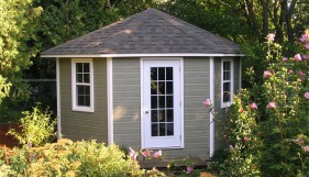 Catalina shed design 11 ft with a white door and windows in a backyard seen from the frontage. ID number 1785-1.