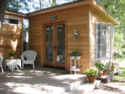 Urban Studio shed plan 10x12 in a garden with cedar channel and single french door. ID number-