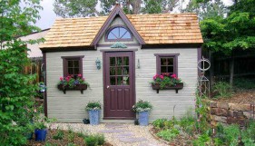 Telluride shed design 10 x 16 with a doomer window in a garden seen from the frontage. ID number 3290-1.