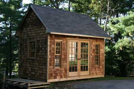 cooper creek garden shed plan 10x14 with cedar shingle siding and double french doors in a backyard. ID number