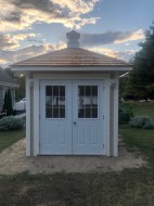 Cedar Sonoma shed design 8' x 8' in a backyard featuring metal double door as seen from the front. Id number 5752.